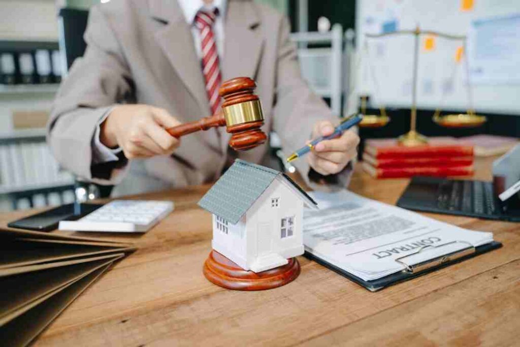 Lawyer with gavel, contract, and a model house, focusing on property law.